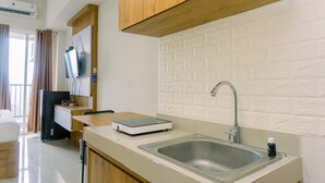 A modern kitchen with a built-in sink, wooden cabinets, and a white brick backsplash.