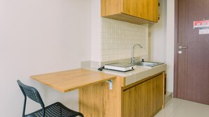 A small kitchenette with a wooden countertop, a sink, and a chair.