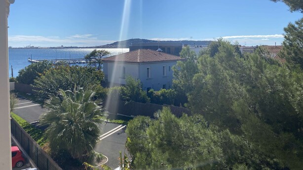 A coastal building with a tiled roof, surrounded by trees and a clear view of the sea. - T1 Loft with Air Conditioning, Parking and Wifi in Balaruc-les-Bains (Balaruc-les-Bains)