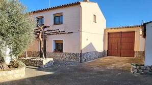 Un bâtiment à deux étages, doté de fondations en pierre et d’un toit recouvert de tuiles.
