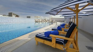 Ein Poolbereich mit Liegestühlen und Sonnenschirmen.