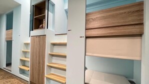 Un vestidor amplio con varias estanterías y un armario empotrado.