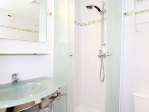 A bathroom with a glass shower enclosure, a glass sink, and a white toilet. - Charming Mezzanine T1, A/C, Thau View (Balaruc-les-Bains)