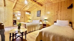 A wooden cabin with two beds, a small table with a vase, and a mirror. - Dar l'eau vive (Bine el Ouidane)