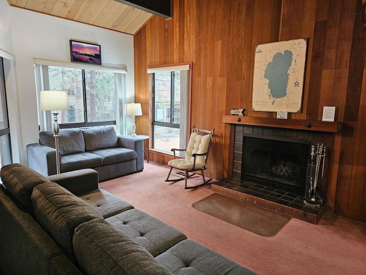 A cozy living room with a fireplace, a large map on the wall, and a comfortable seating area.