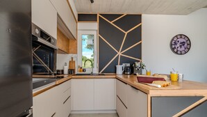 Eine moderne Küche mit Backofen, Kaffeemaschine und einer Holzarbeitsplatte.