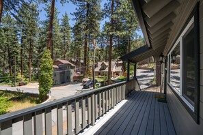 A wooden deck with a railing, overlooking a street with houses and a clear sky. - Foothill Folly 4 Bedroom Home by RedAwning (Zephyr Cove)