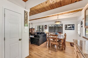 A spacious living area with a wooden ceiling, a dining table with chairs, a sofa, and a fireplace. - Cozy Mountain Hideaway 3 Bedroom Home by RedAwning (Incline Village)