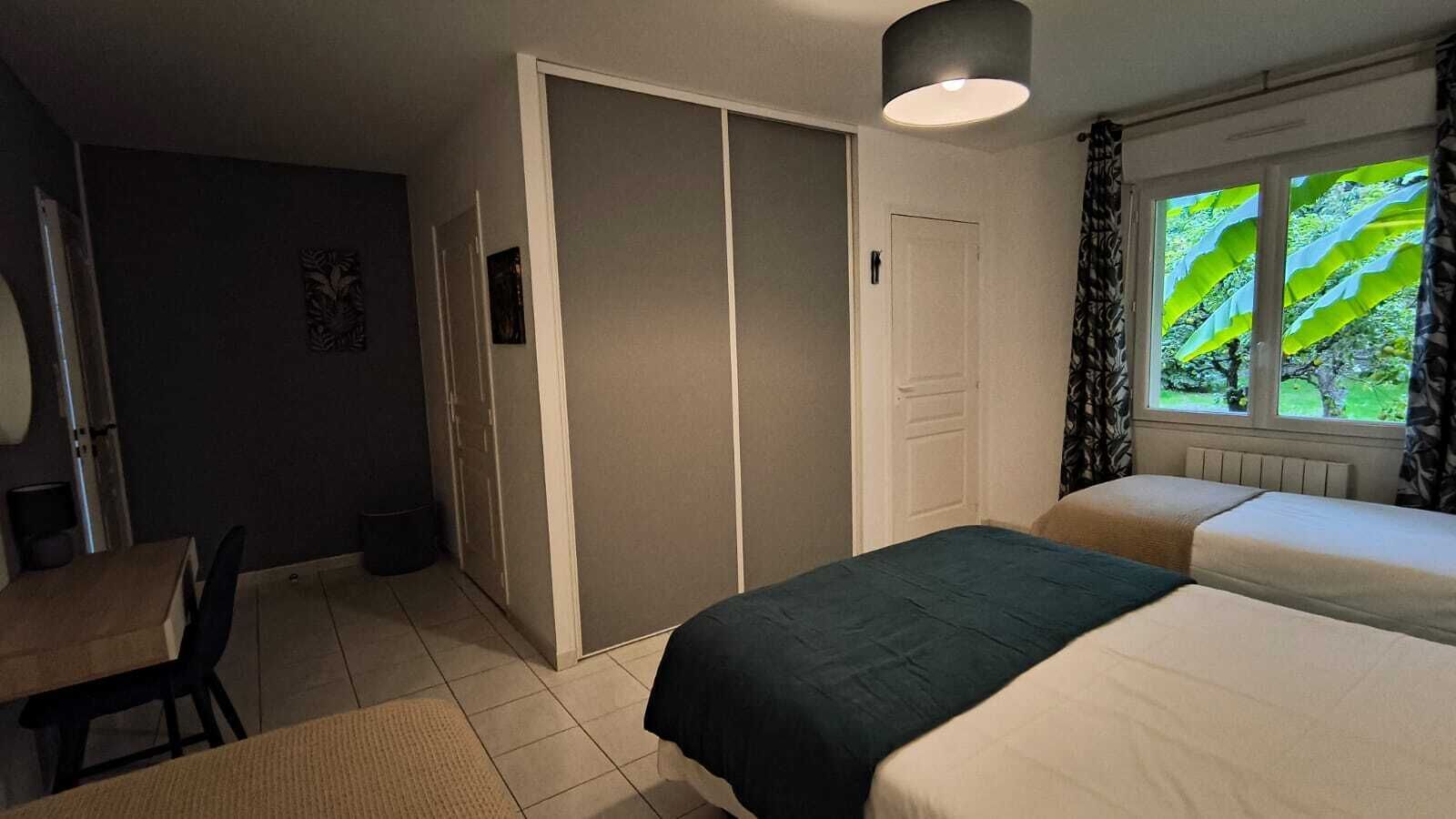Un dormitorio con dos camas, un escritorio y un armario.
