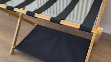 A wooden floor with a black canvas hammock.