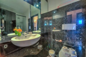 A modern bathroom with a large white sink, a mirror, and a marble backsplash. - Residenza Borgo Rustico (Collina d'Oro)