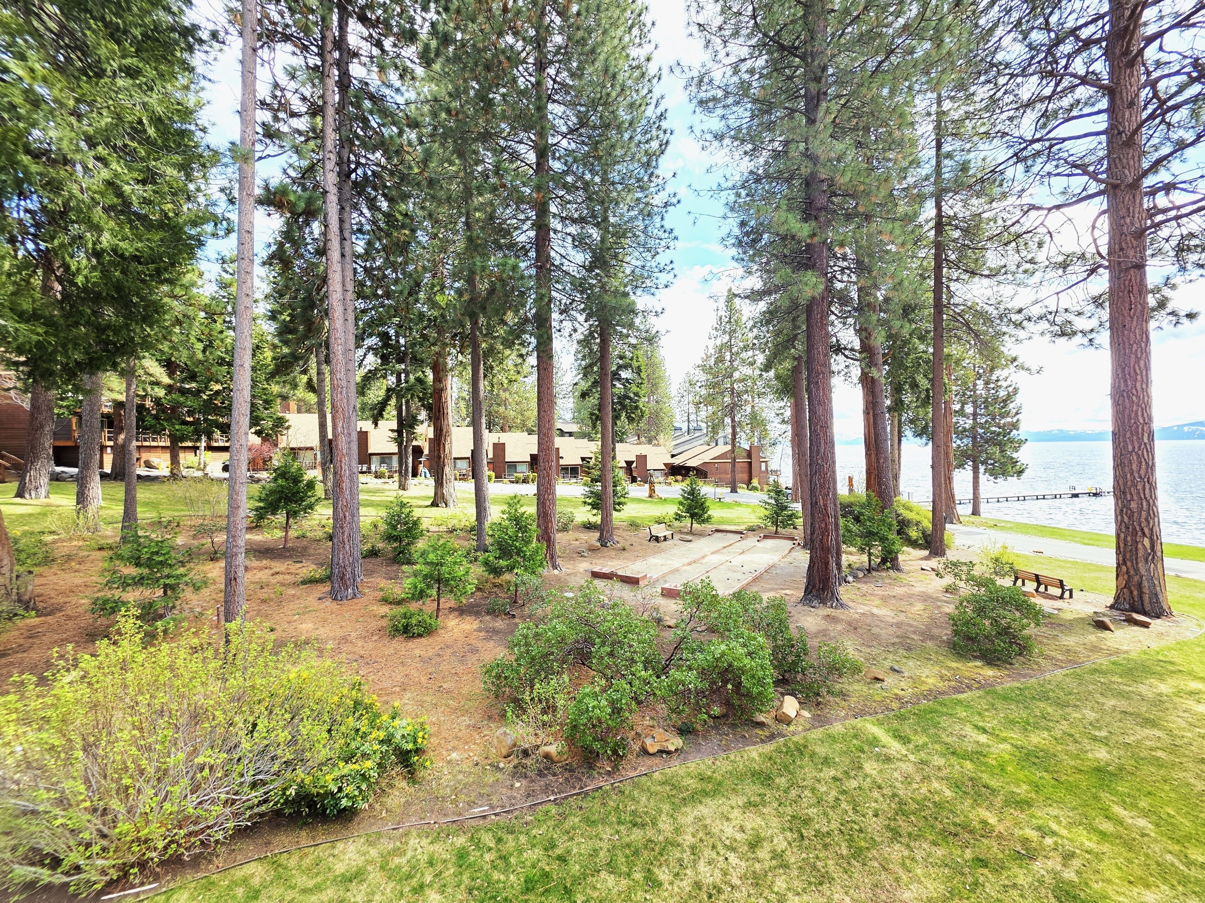 A lodge with multiple cabins, a grassy area, and a view of the lake.