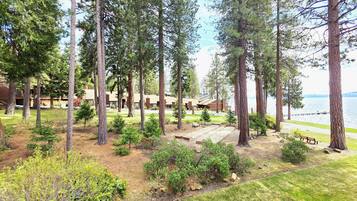 A lodge with multiple cabins, a grassy area, and a view of the lake.
