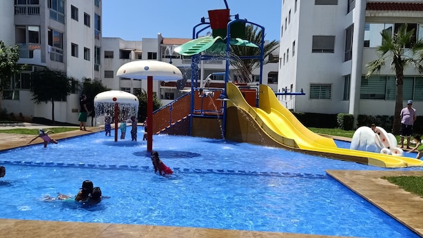 Une piscine avec un toboggan et une aire de jeux.