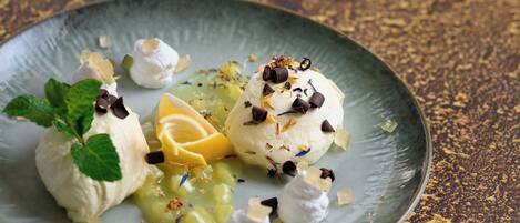 A dessert plate with ice cream and fruit garnishes.