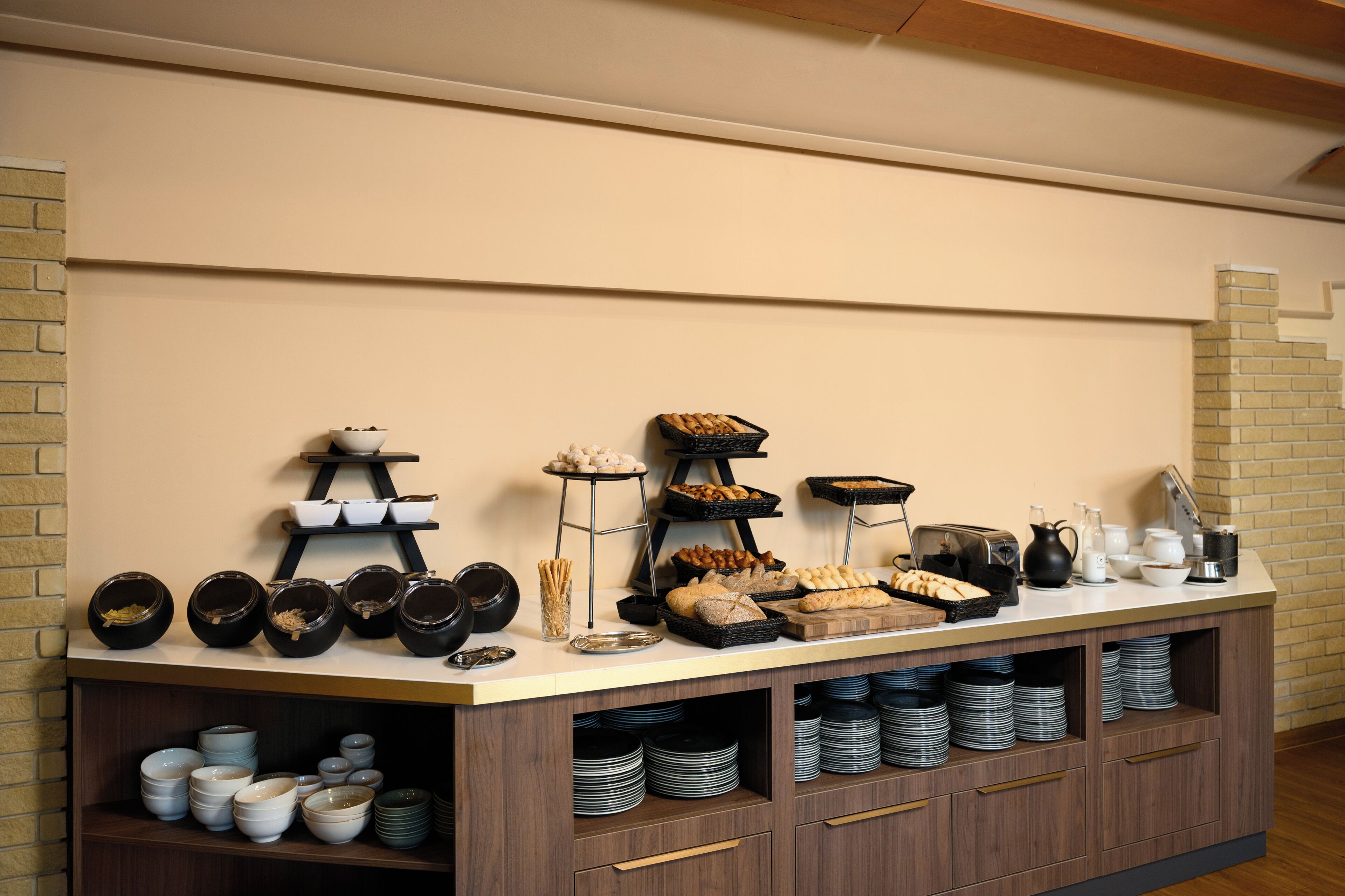 A buffet setup with various food items and dishes.