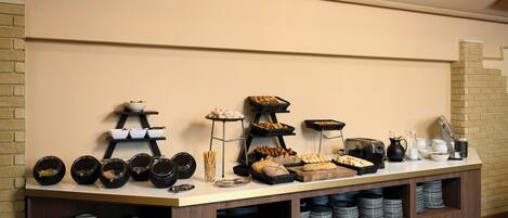 A buffet setup with various food items and dishes.