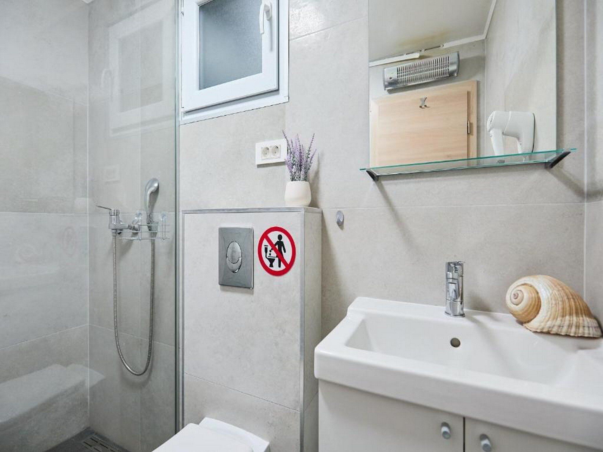 A modern bathroom with a shower, toilet, and sink.