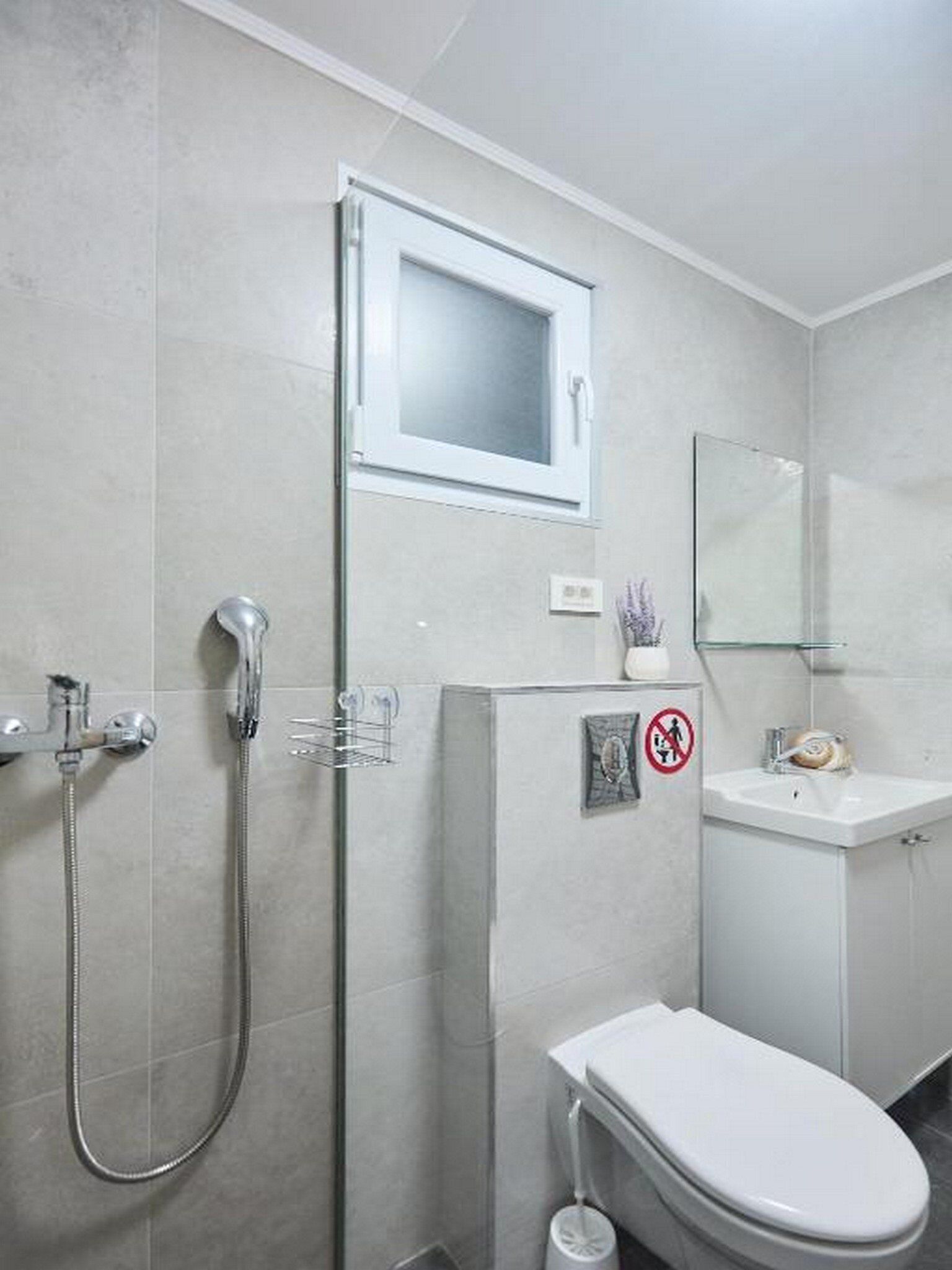 A bathroom with a shower, toilet, and sink.