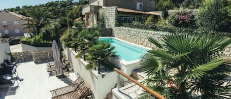 Una piscina al aire libre de temporada, sombrillas