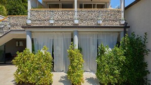 A two-story building with a balcony, stone wall, and potted plants. - Palm Tree Apartments (Dubrovnik)