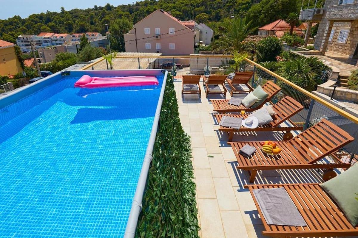 A swimming pool with lounge chairs and a view of a hillside.