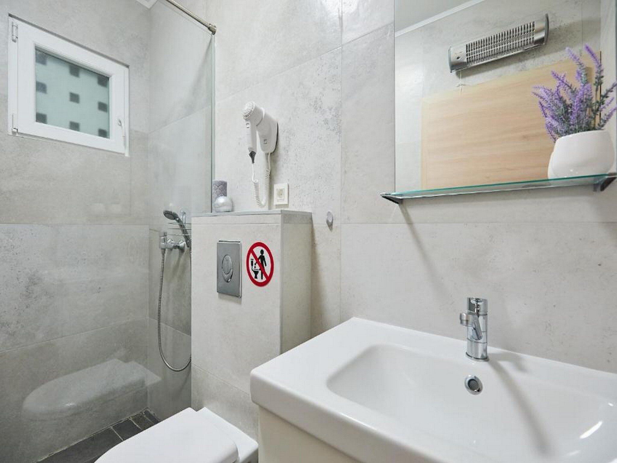Une salle de bain moderne équipée d’une douche, de toilettes et d’un lavabo.