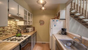 A compact kitchen with a gas stove, microwave, sink, and a refrigerator. - Alpine Getaway 3 Bedroom Home by RedAwning (Tahoe City)