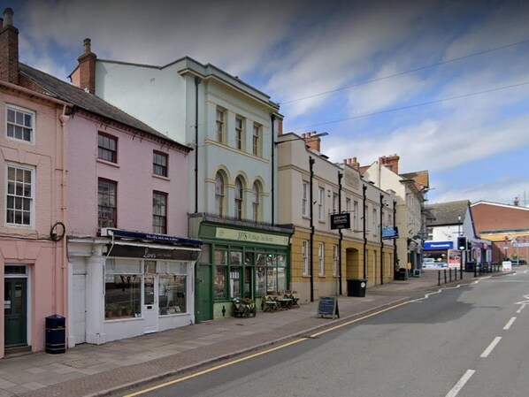A street with buildings, including a shop with a green awning and a sign that says "JOURNEY'S END". - Cosy Twin or Double Studio Near Shearsby, England (Lutterworth)