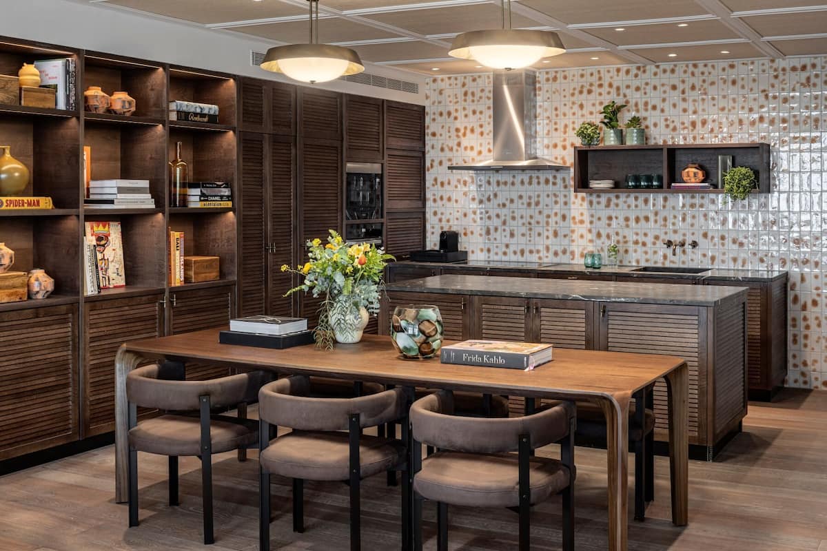 A modern kitchen with a central island, dark wood cabinetry, and a tiled backsplash.