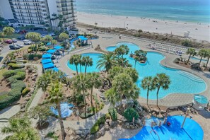 Ein Resort mit mehreren Swimmingpools, Palmen und Blick auf den Strand.