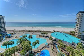A resort with a large pool area, beach access, and high-rise buildings.
