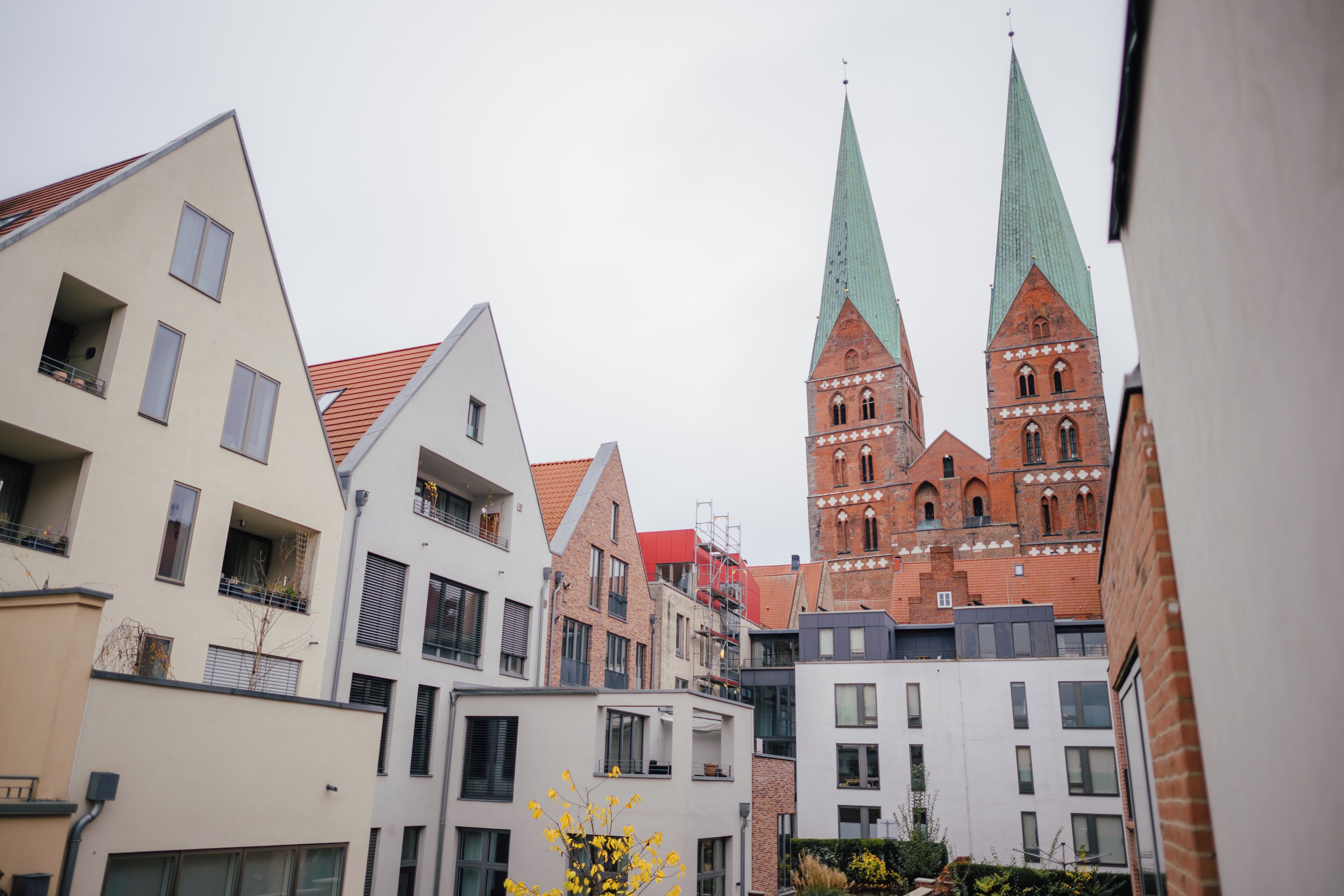 En vy över en stadsbild med moderna byggnader och en historisk kyrka med två torn.