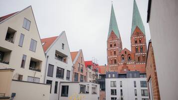 En vy över en stadsbild med moderna byggnader och en historisk kyrka med två torn.