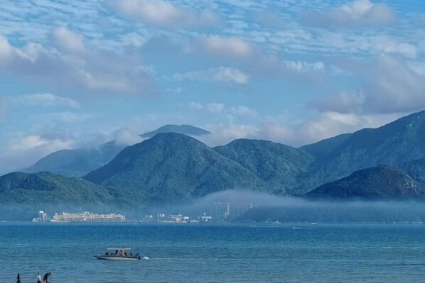 A body of water with mountains in the background and a boat in the foreground.
