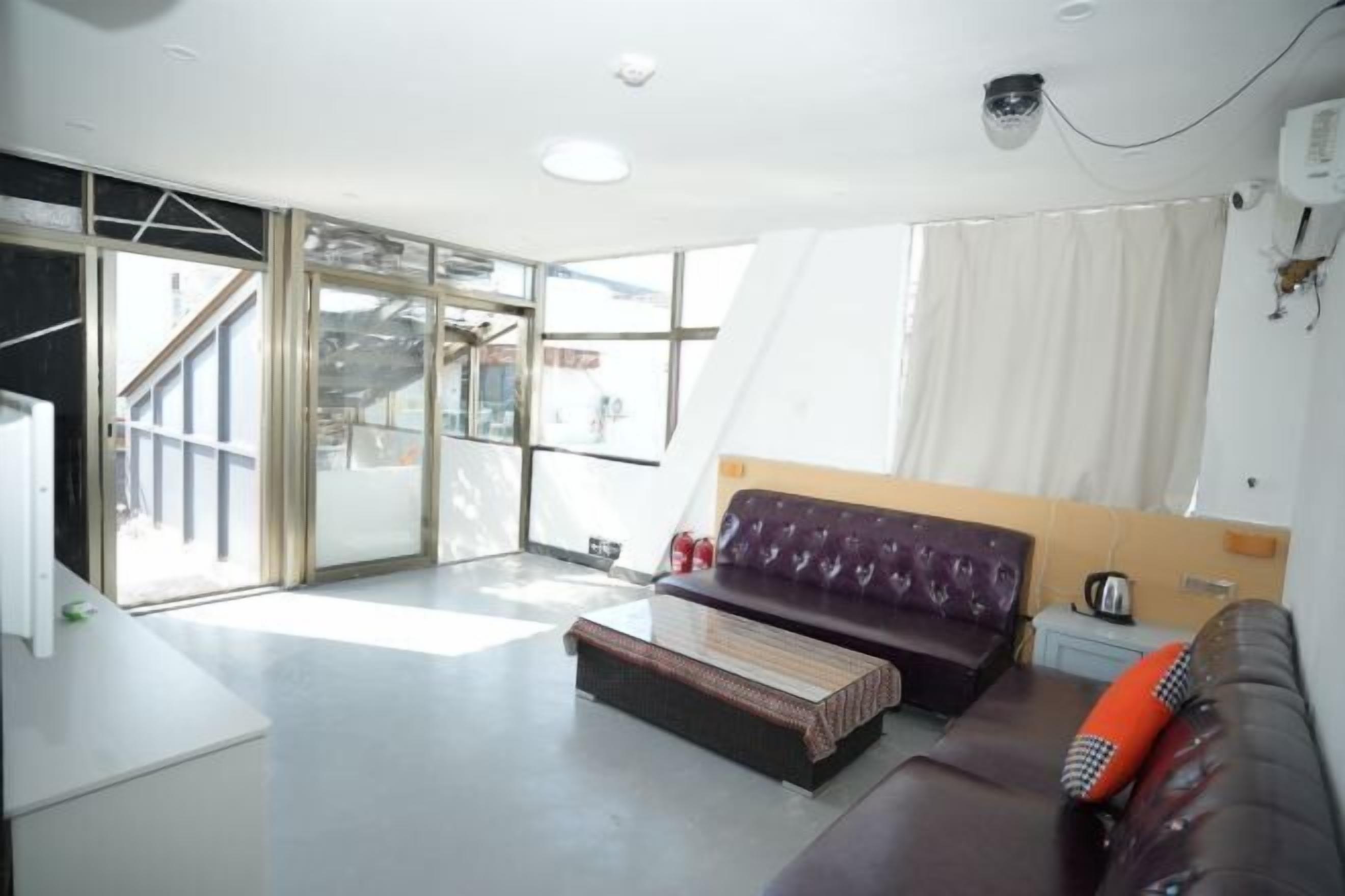 Sala de estar moderna com sofá, mesa de centro e vista para uma escada que dá para uma área externa.
