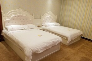 A double bed with a white headboard and matching bedding, a nightstand, and a striped curtain. - Zihong Hotel (Yuxi)