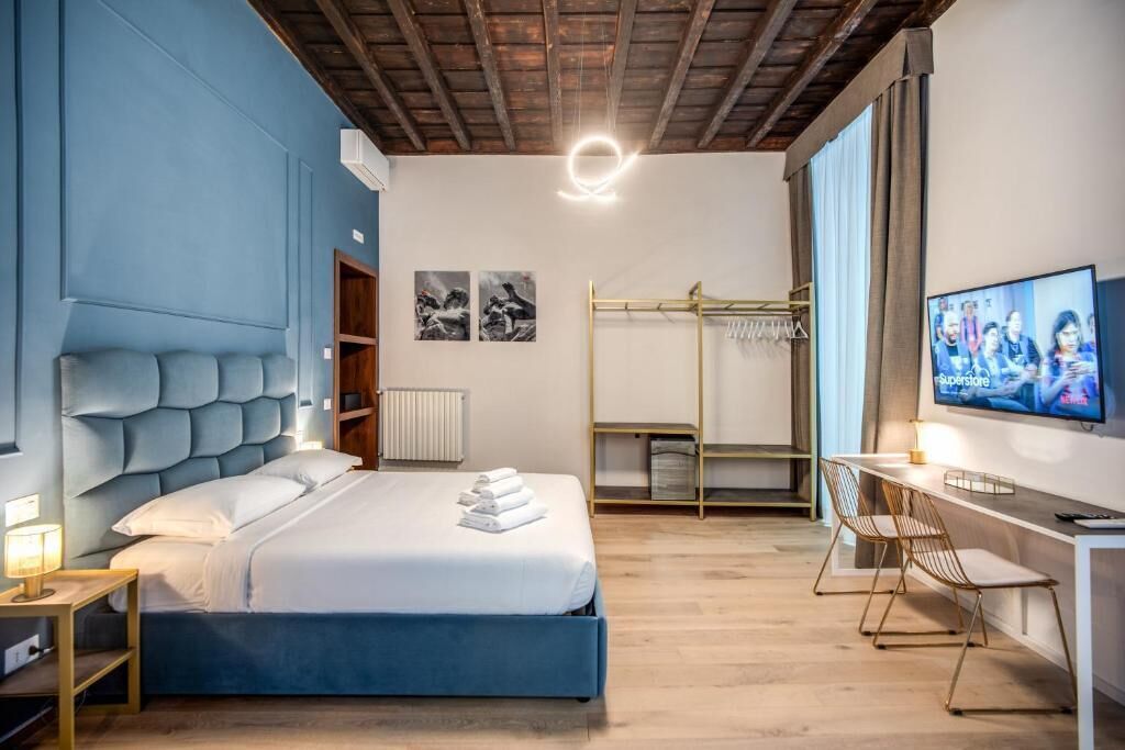 Una habitación de hotel moderna con una cama grande, un escritorio y una televisión.
