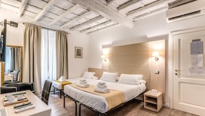 A hotel room with a bed, bedside tables, a desk with a chair, a mirror, and a door with a sign. - Magenta Collection Cancello (Rome)