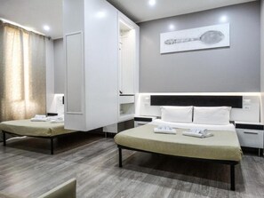 Ein modernes Hotelzimmer mit zwei Betten, einem großen Spiegel und einem Wandbild.