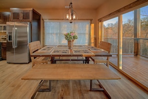 Un coin repas avec une table en bois, des chaises et un vase central décoré de fleurs.