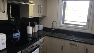 Een koelkast met diepvriezer, een microgolfoven, een oven