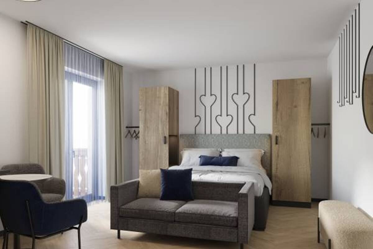 Una habitación de hotel moderna con una cama, un sofá, una silla y un escritorio.