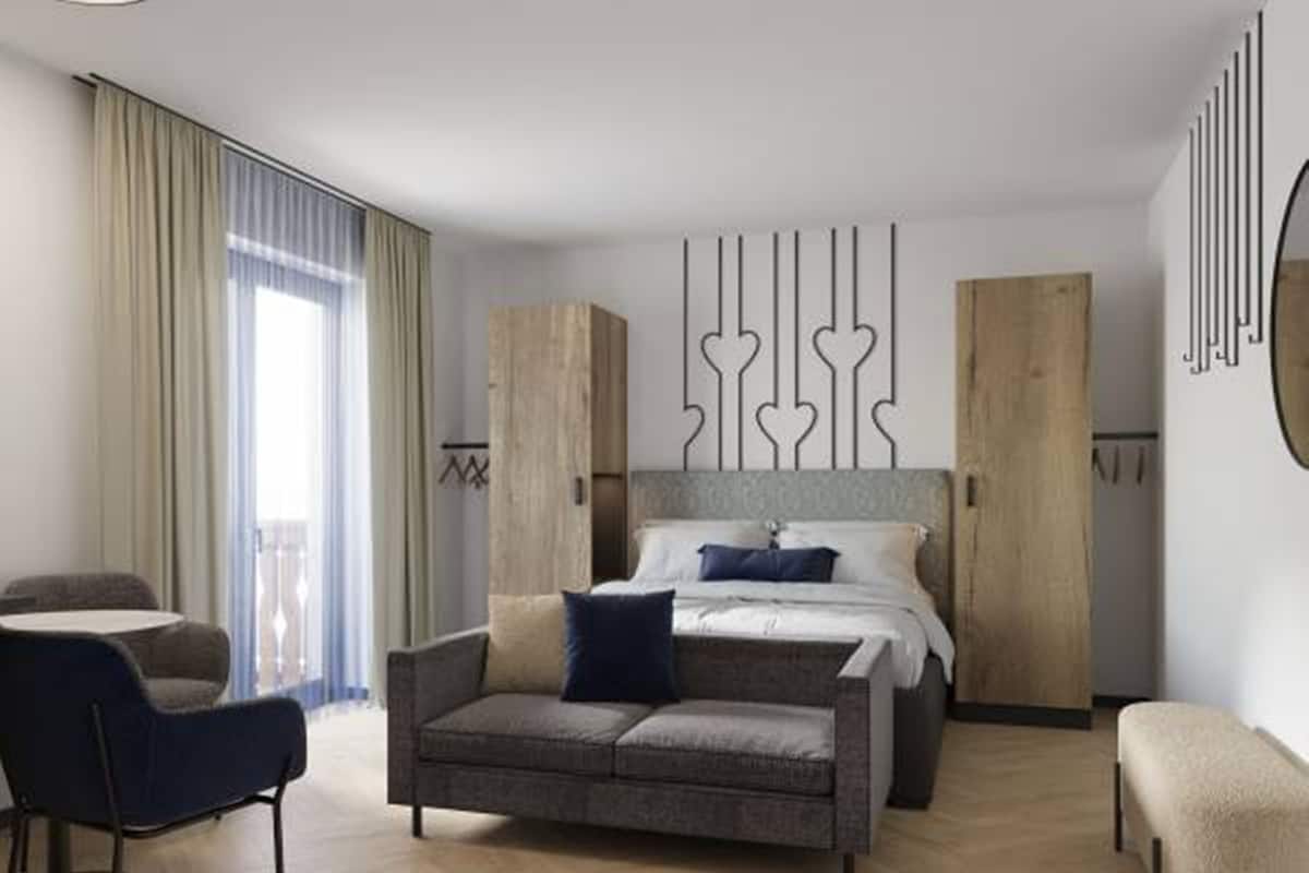 Una habitación de hotel moderna con una cama, un sofá, una silla y un escritorio.