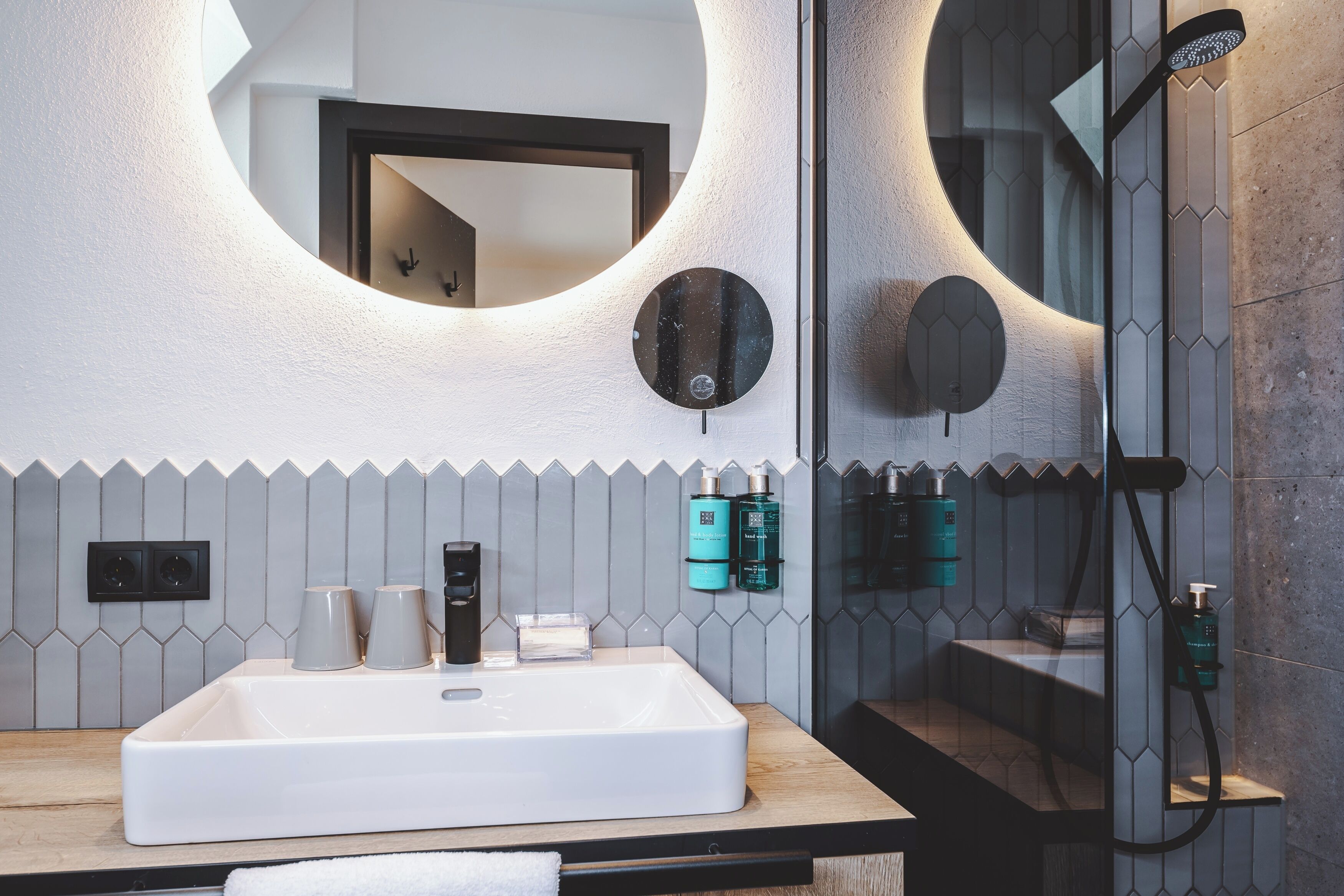 Un baño moderno con un lavabo grande, un espejo y una ducha.