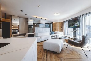 Suite Deluxe, 4 habitaciones, sauna | Zona de estar | Televisión de pantalla plana de 30 pulgadas con canales por cable