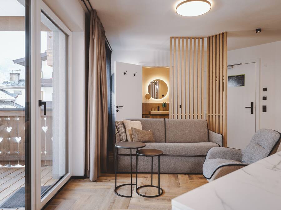 Un interior moderno con un sofá, una mesita y una silla.