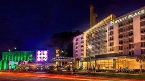 A multi-story hotel with a prominent 'Hyatt Place' sign, a covered entrance, and a well-lit facade.