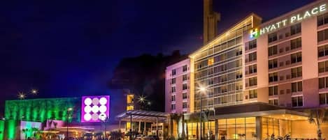 A multi-story hotel with a prominent 'Hyatt Place' sign, a covered entrance, and a well-lit facade.