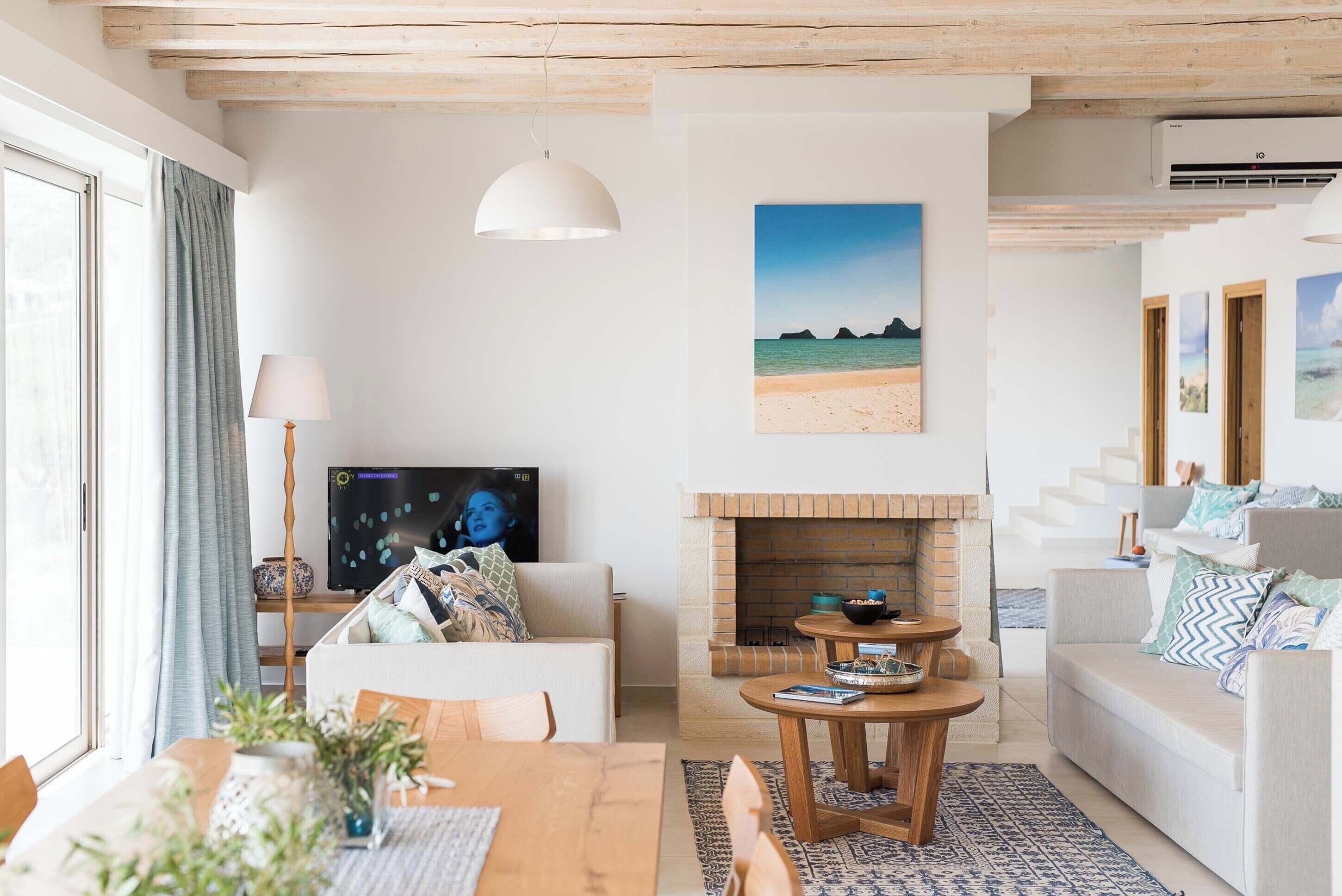 Ein modernes Wohnzimmer mit Kamin, Essbereich und Fernseher.